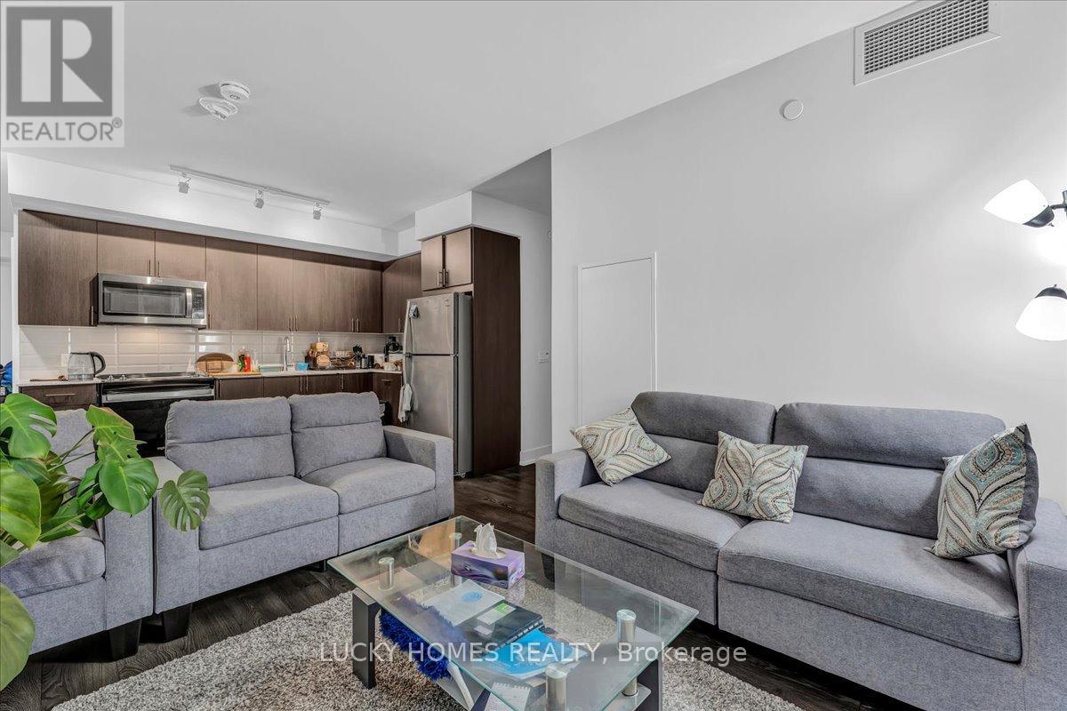 A living room with a grey couch and a glass coffee table.