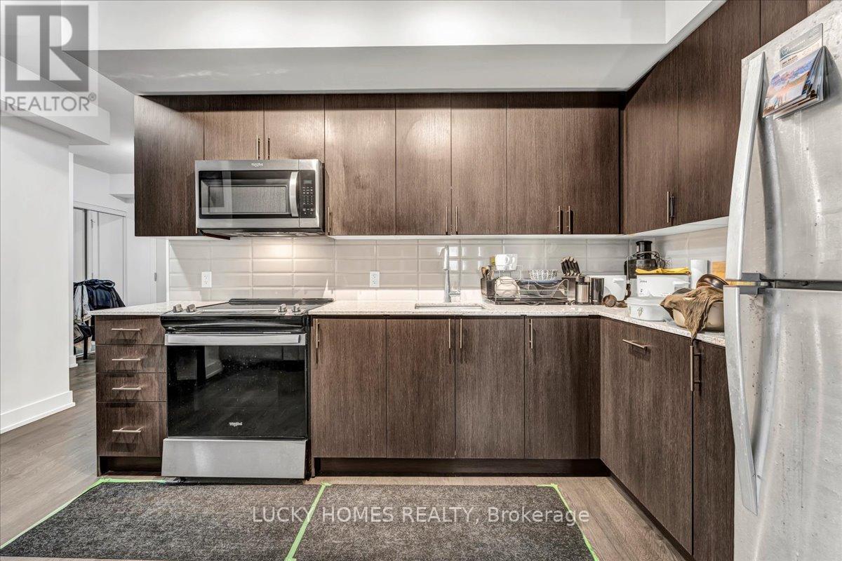 A kitchen with brown cabinets and a white fridge.