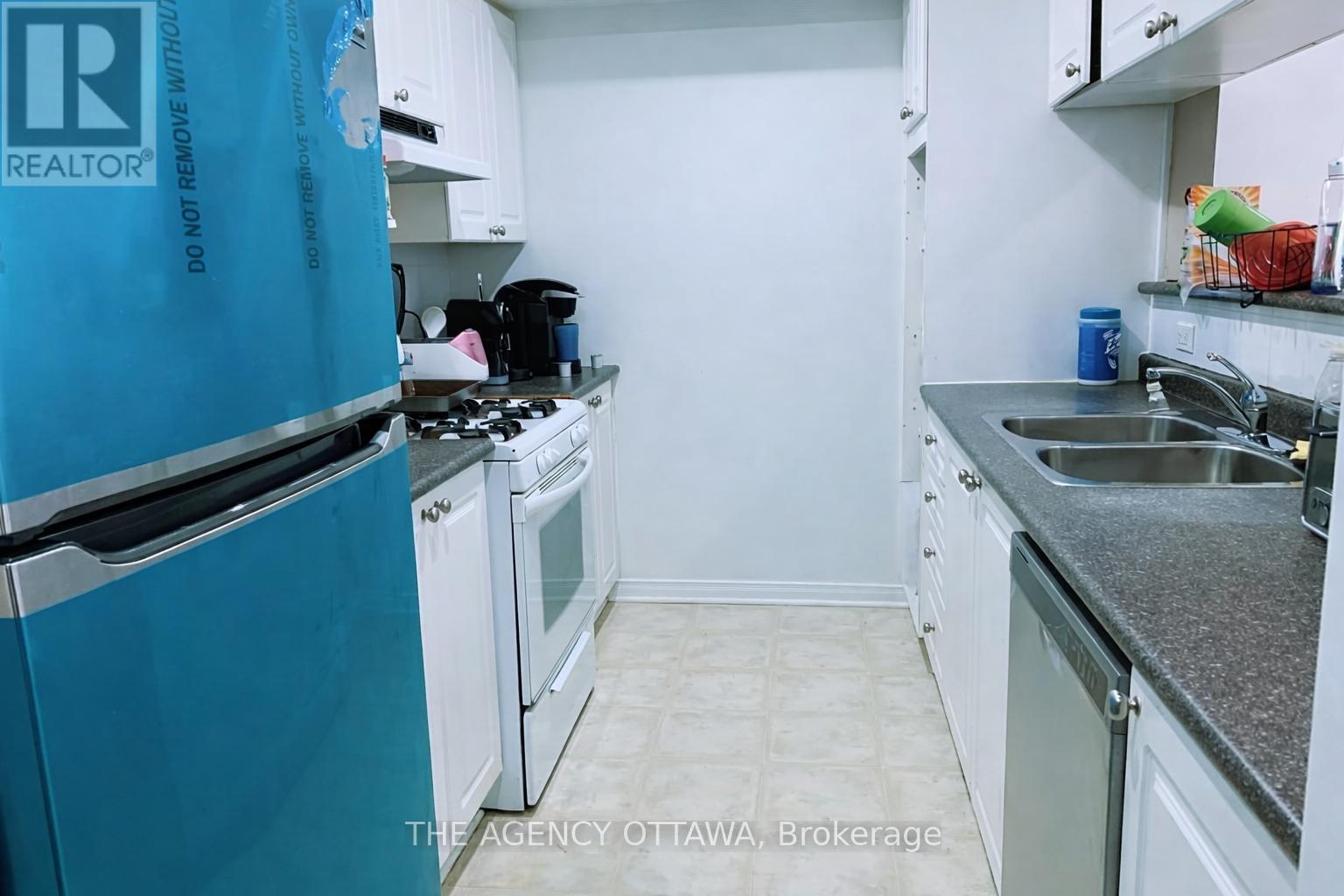A kitchen with a blue tarp on the refrigerator.