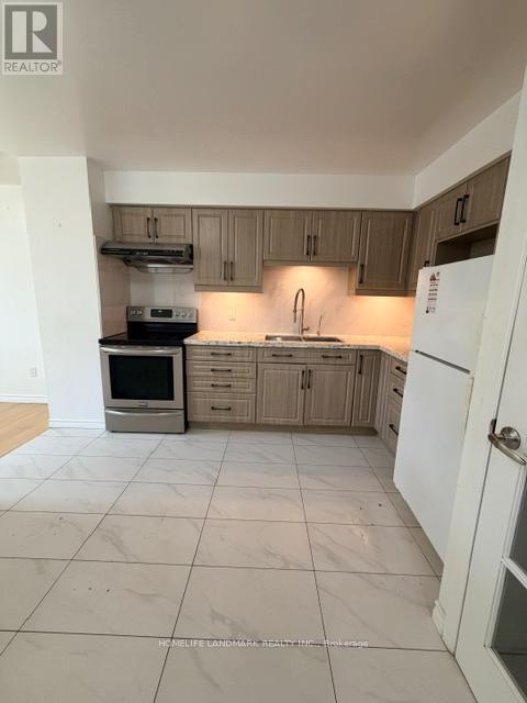 A kitchen with a white fridge and wooden cabinets.