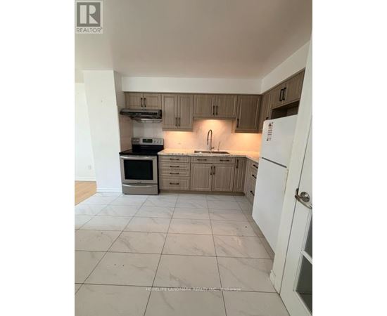 A kitchen with a white fridge and wooden cabinets.
