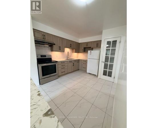 A kitchen with a white refrigerator and wooden cabinets.