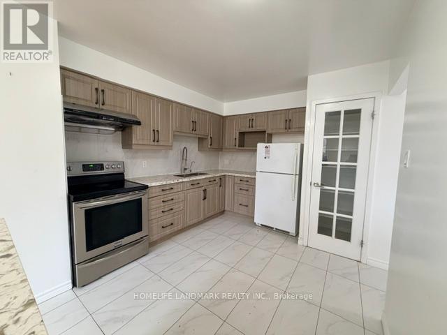 A kitchen with a white fridge and wooden cabinets.