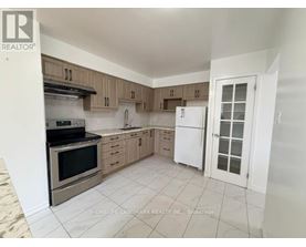 A kitchen with a white fridge and wooden cabinets.