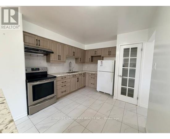 A kitchen with a white fridge and wooden cabinets.