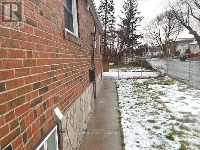 A brick house with a snow covered ground.