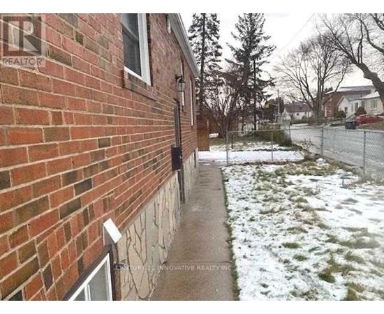 A brick house with a snow covered ground.