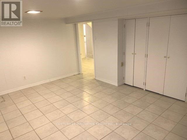 A spacious room with white cabinets and tiled flooring.