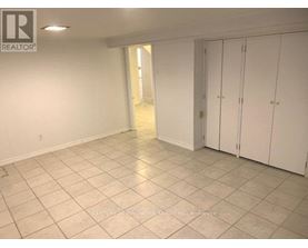 A spacious room with white cabinets and tiled flooring.