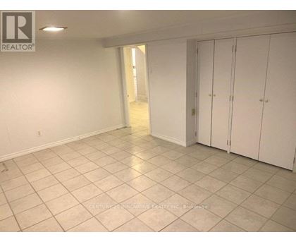 A spacious room with white cabinets and tiled flooring.
