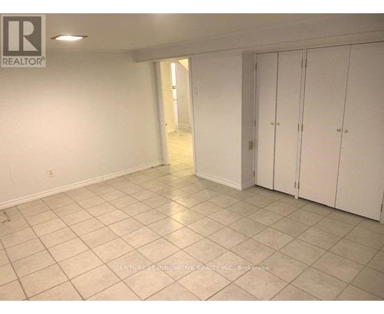 A spacious room with white cabinets and tiled flooring.