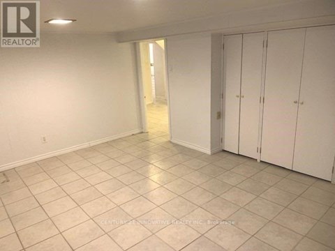 A spacious room with white cabinets and tiled flooring.