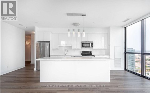 A modern kitchen with white cabinets and a large island.
