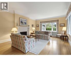 A living room with a couch, chair, and fireplace.