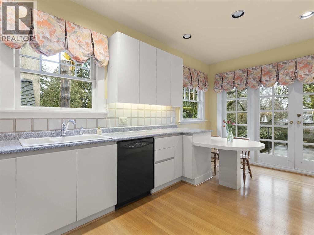 A kitchen with white cabinets and a black dishwasher.