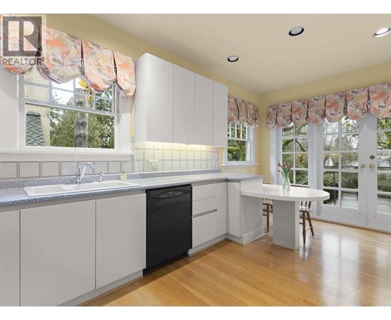 A kitchen with white cabinets and a black dishwasher.