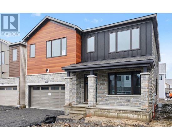 A modern house with a garage is under construction.