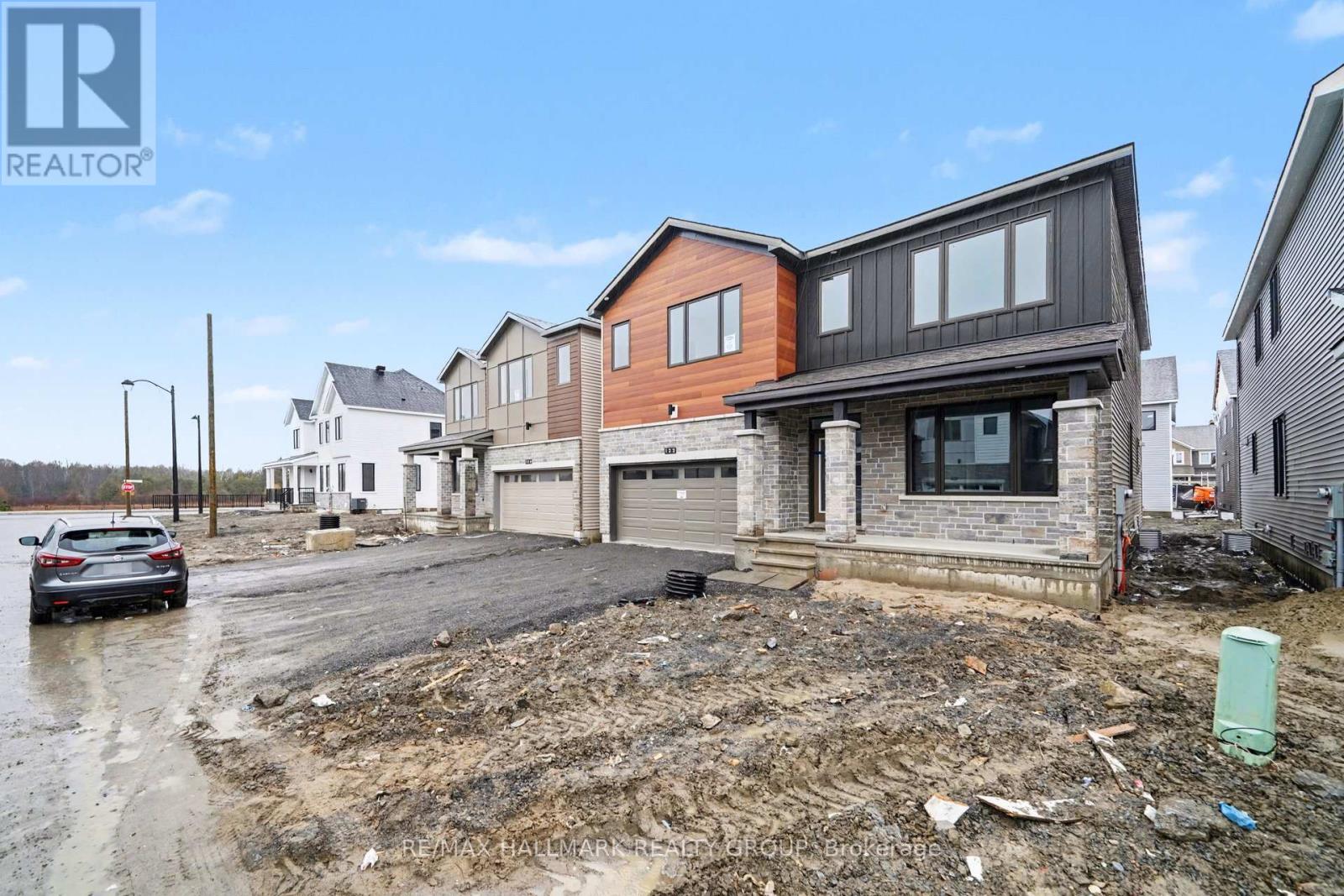 A house under construction with a car parked in front.