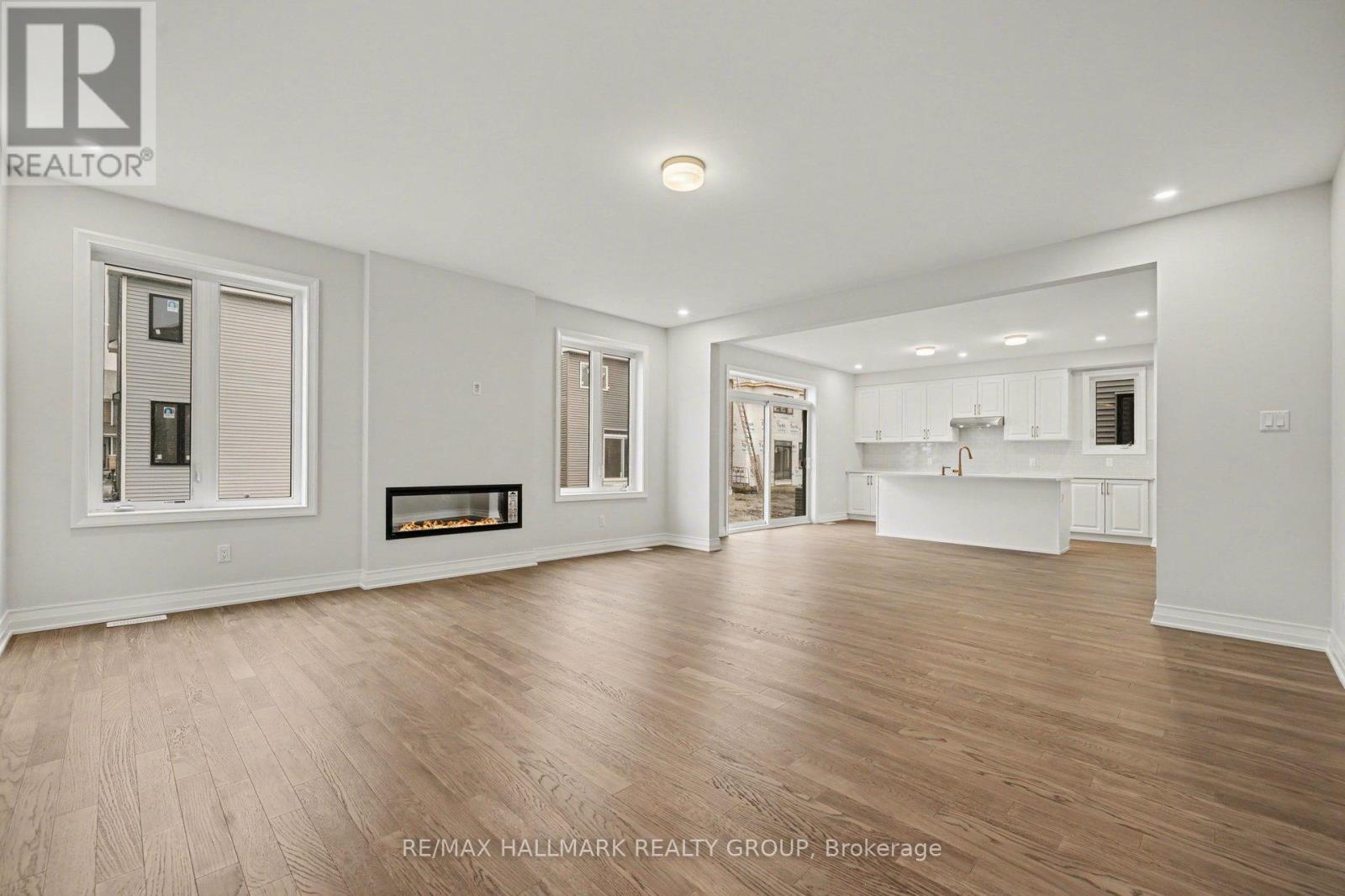 A spacious room with wooden flooring and white walls.