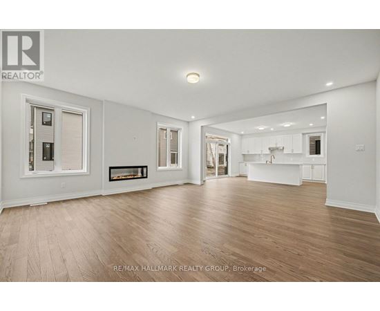 A spacious room with wooden flooring and white walls.