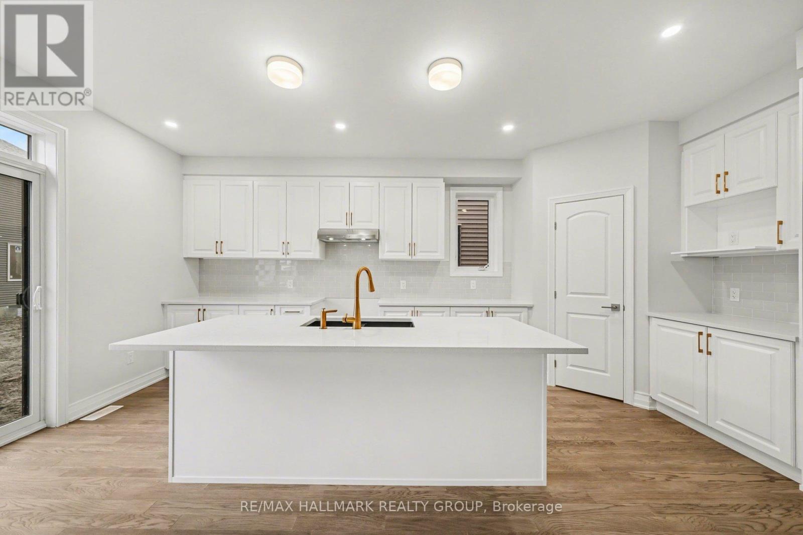 A white kitchen with a sink and cabinets.