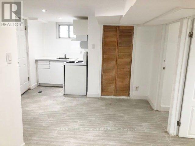 A realtor photo of a kitchen with white cabinets and a wooden door.