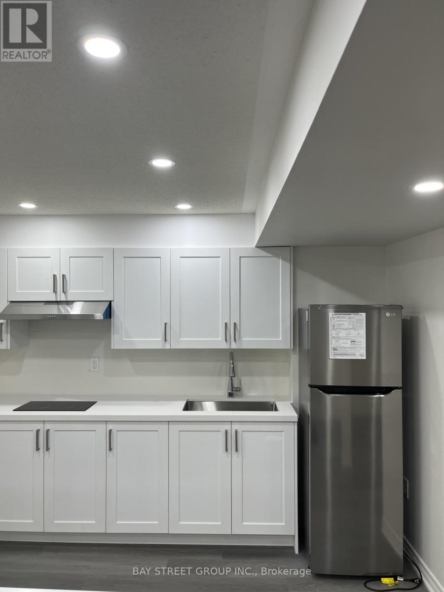 A kitchen with white cabinets and a stainless steel refrigerator.