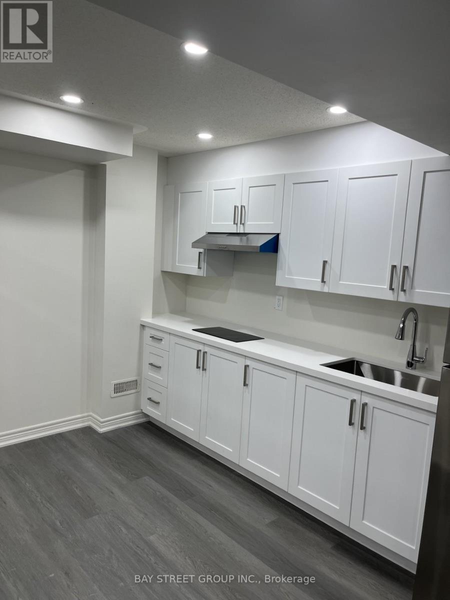 A kitchen with white cabinets and a sink.