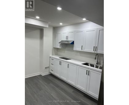 A kitchen with white cabinets and a sink.