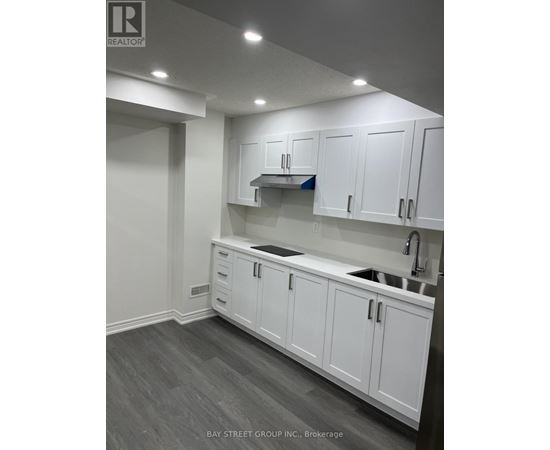 A kitchen with white cabinets and a sink.