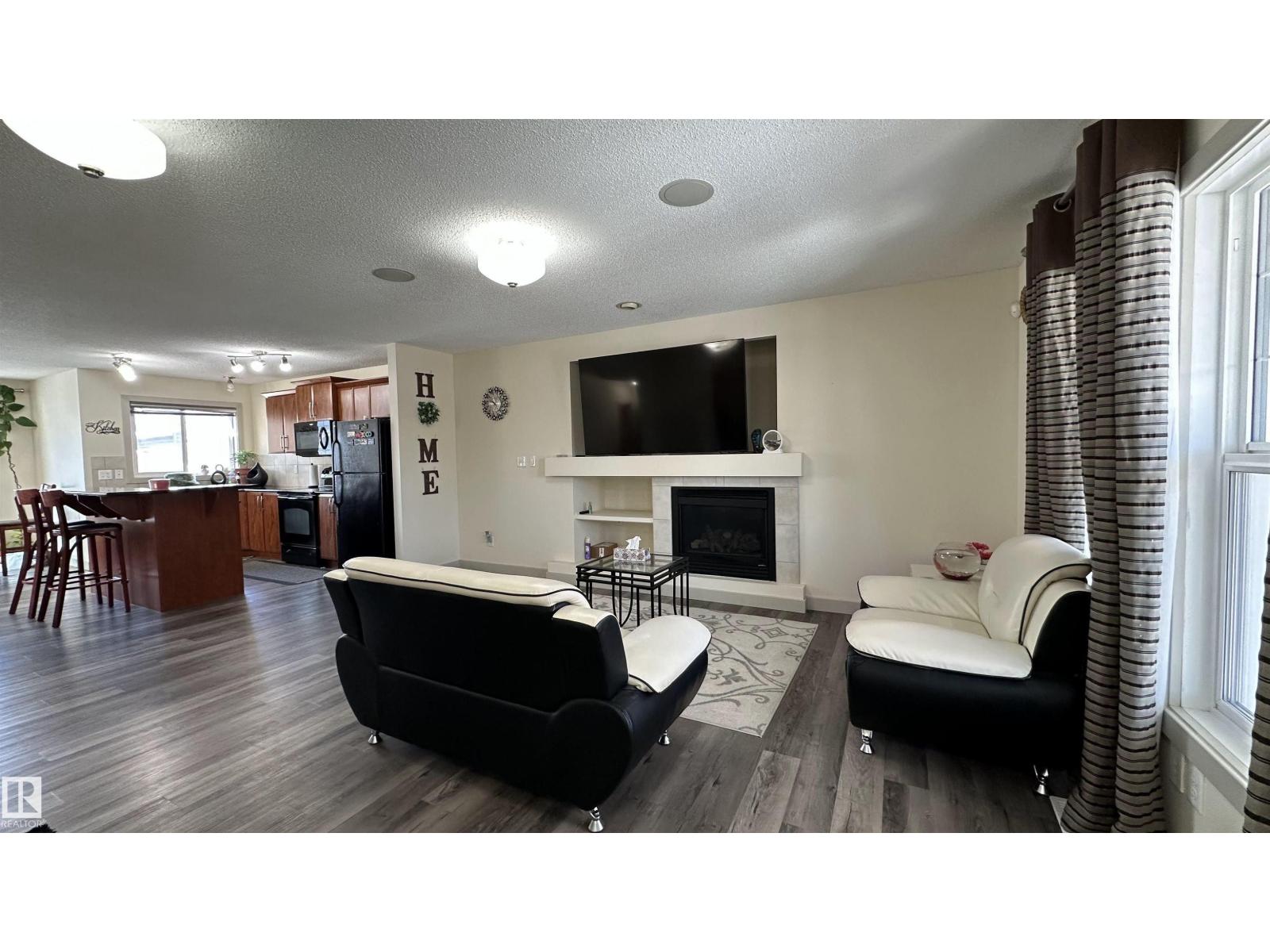 A living room with a fireplace and a television.