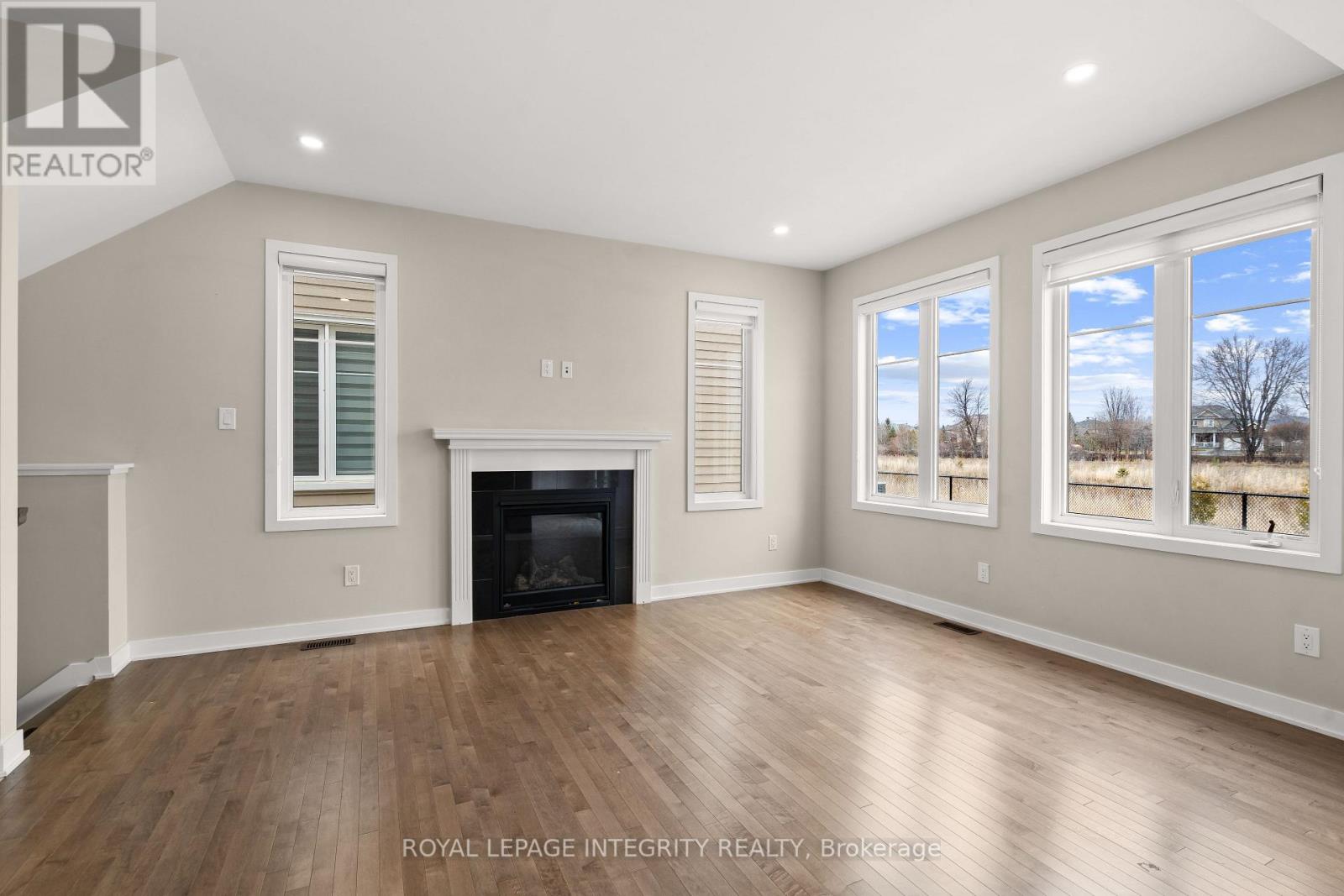 A spacious room with a fireplace and large windows.