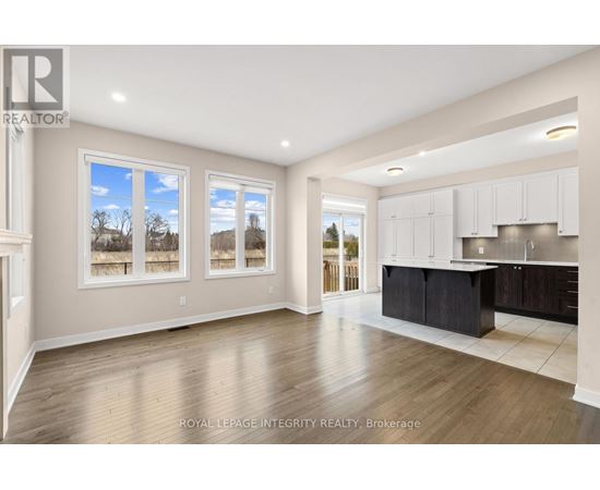 A spacious kitchen with white cabinets and a black island.
