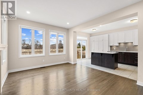 A spacious kitchen with white cabinets and a black island.
