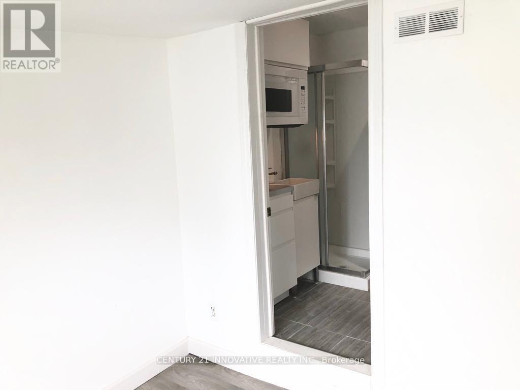 A white refrigerator is in a kitchen with a white wall.