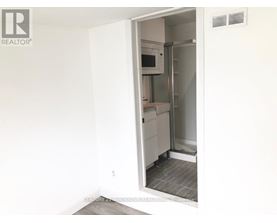 A white refrigerator is in a kitchen with a white wall.