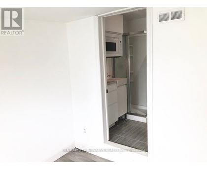 A white refrigerator is in a kitchen with a white wall.
