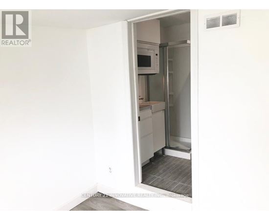 A white refrigerator is in a kitchen with a white wall.