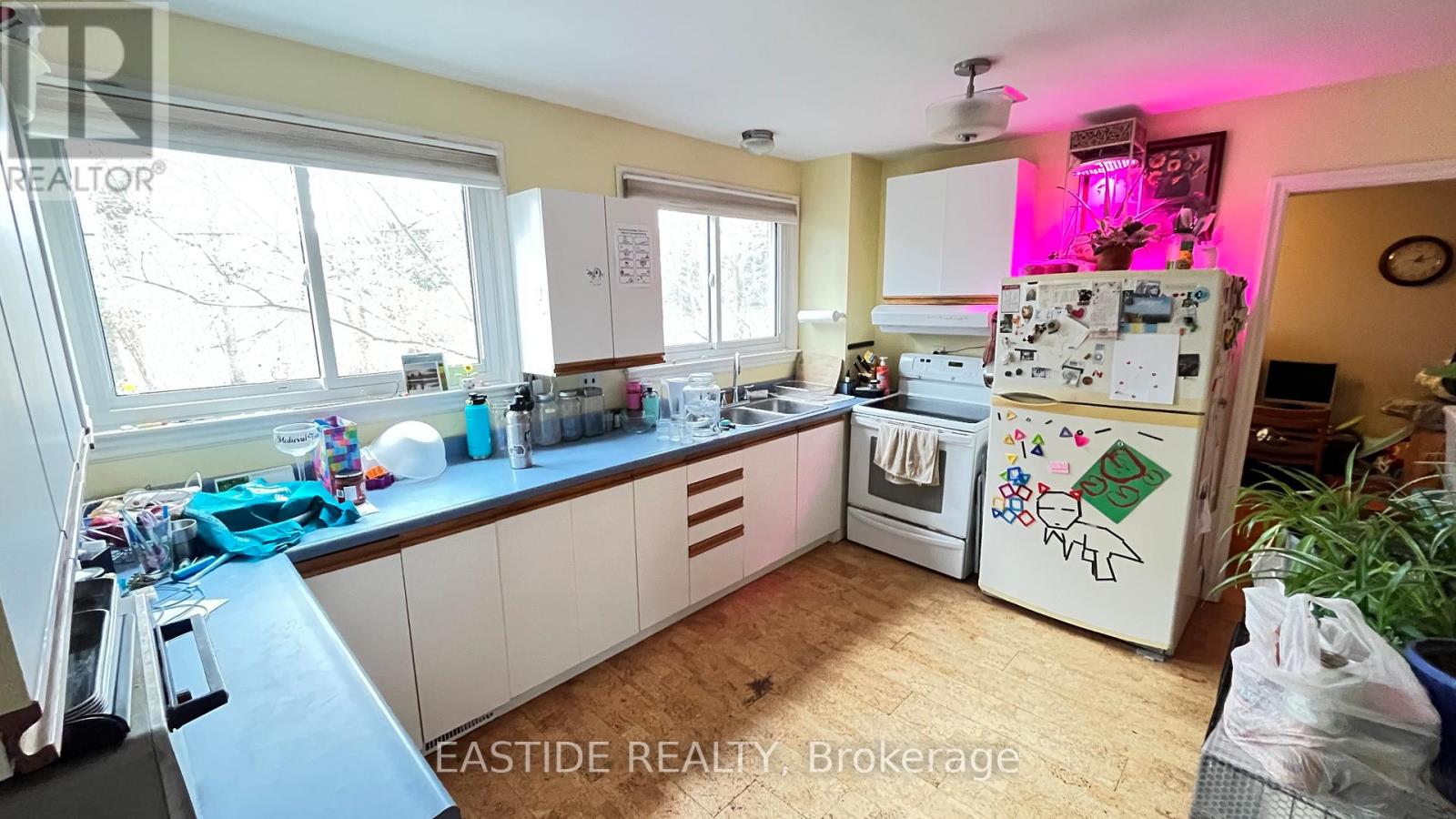 A kitchen with a refrigerator covered in stickers and magnets.