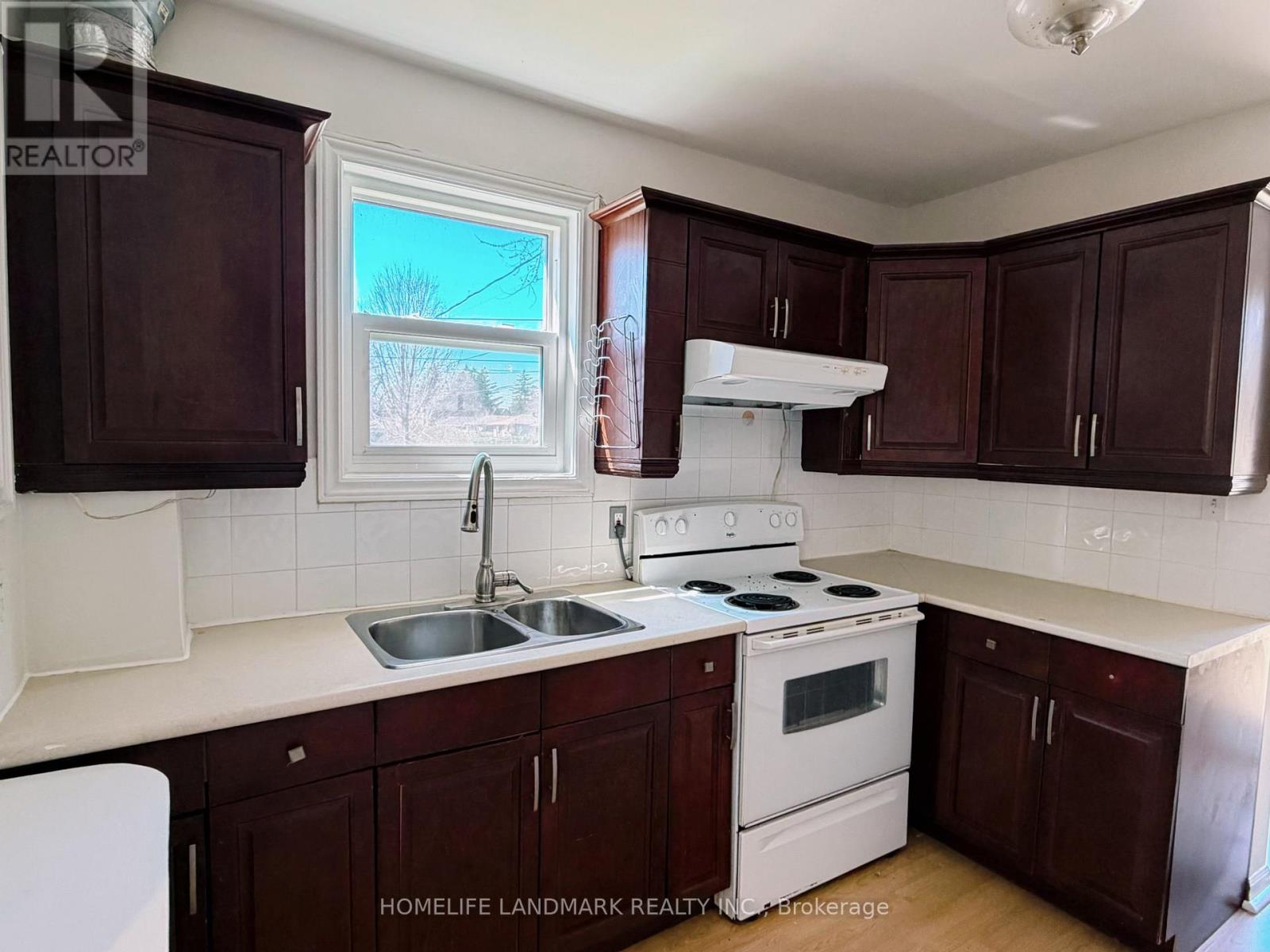 A kitchen with brown cabinets and white appliances.
