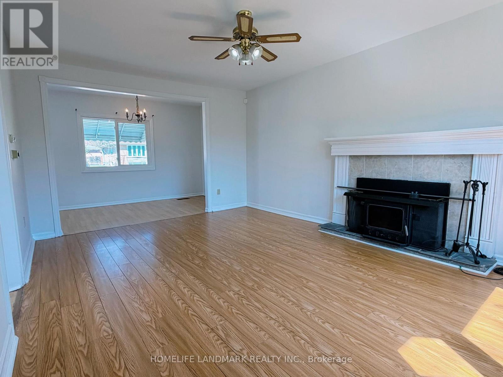 A living room with a fireplace and wood flooring.