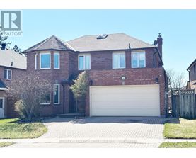 A large brick house with a white garage door in the front yard.