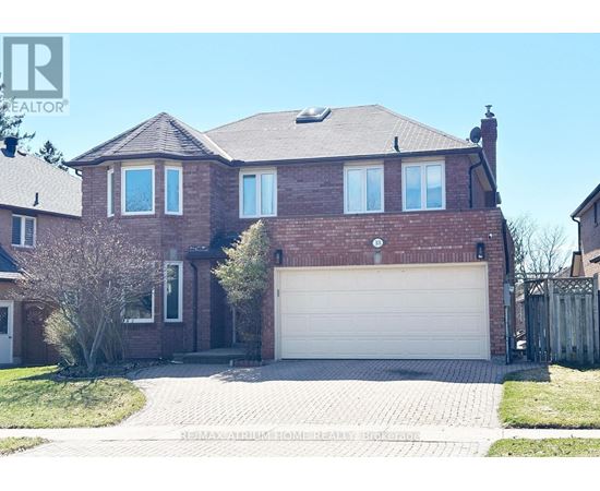 A large brick house with a white garage door in the front yard.