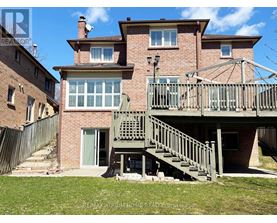 A house with a balcony and stairs leading to the entrance.