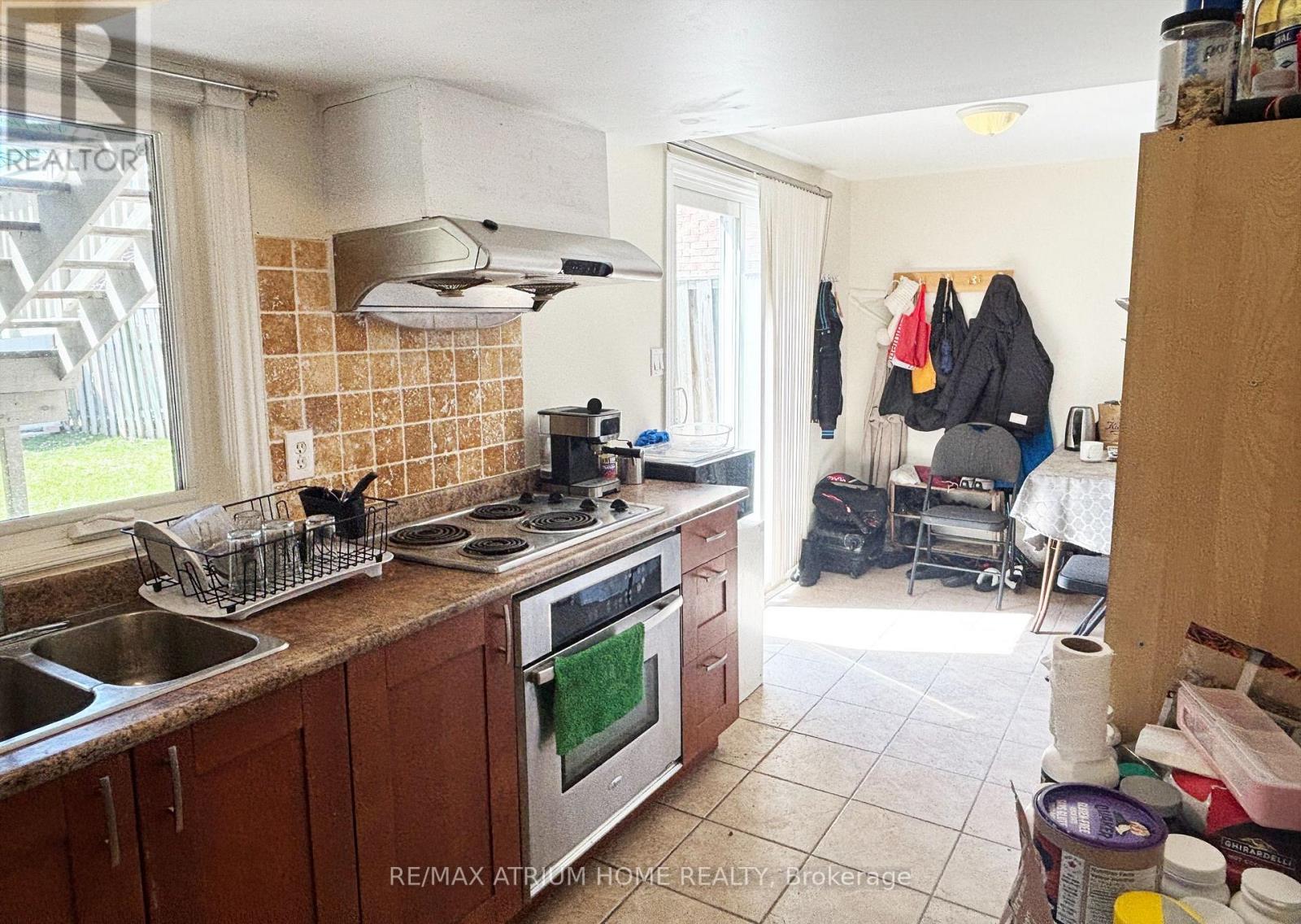 A kitchen with a stove top oven and a sink.