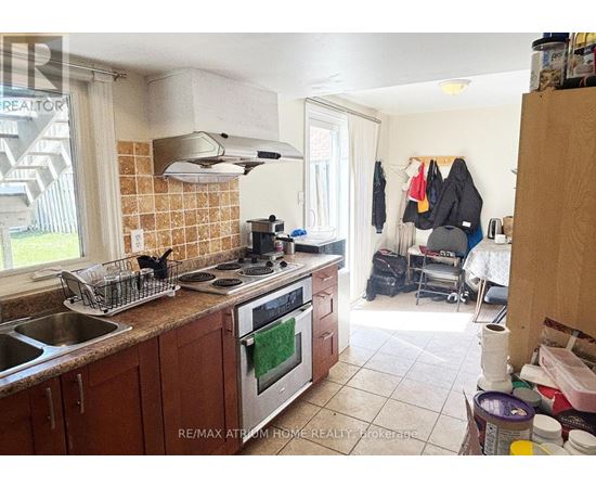 A kitchen with a stove top oven and a sink.