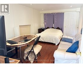 A bedroom with a bed, desk, and chair.