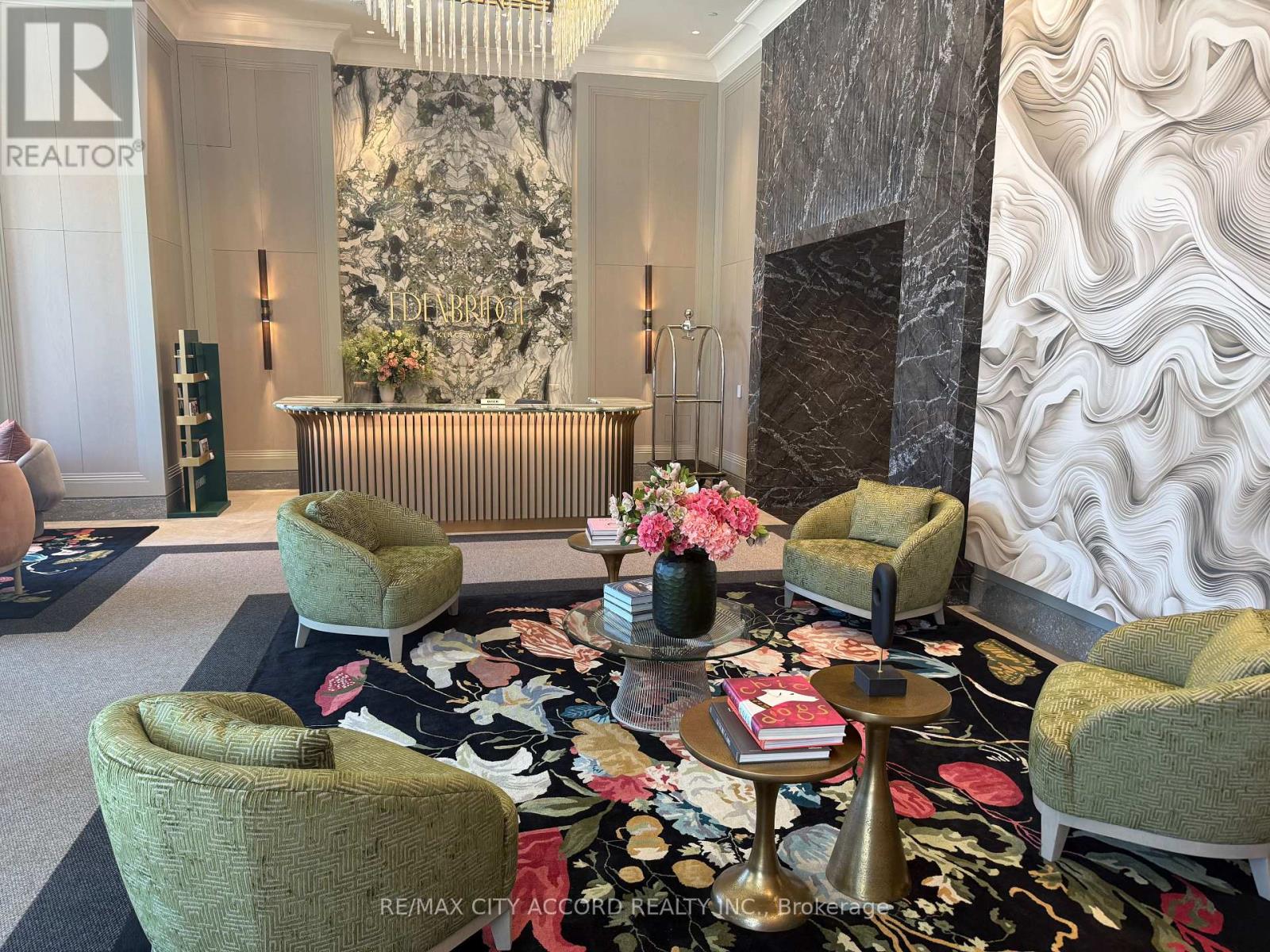 A living room with a green chair and a gold table.
