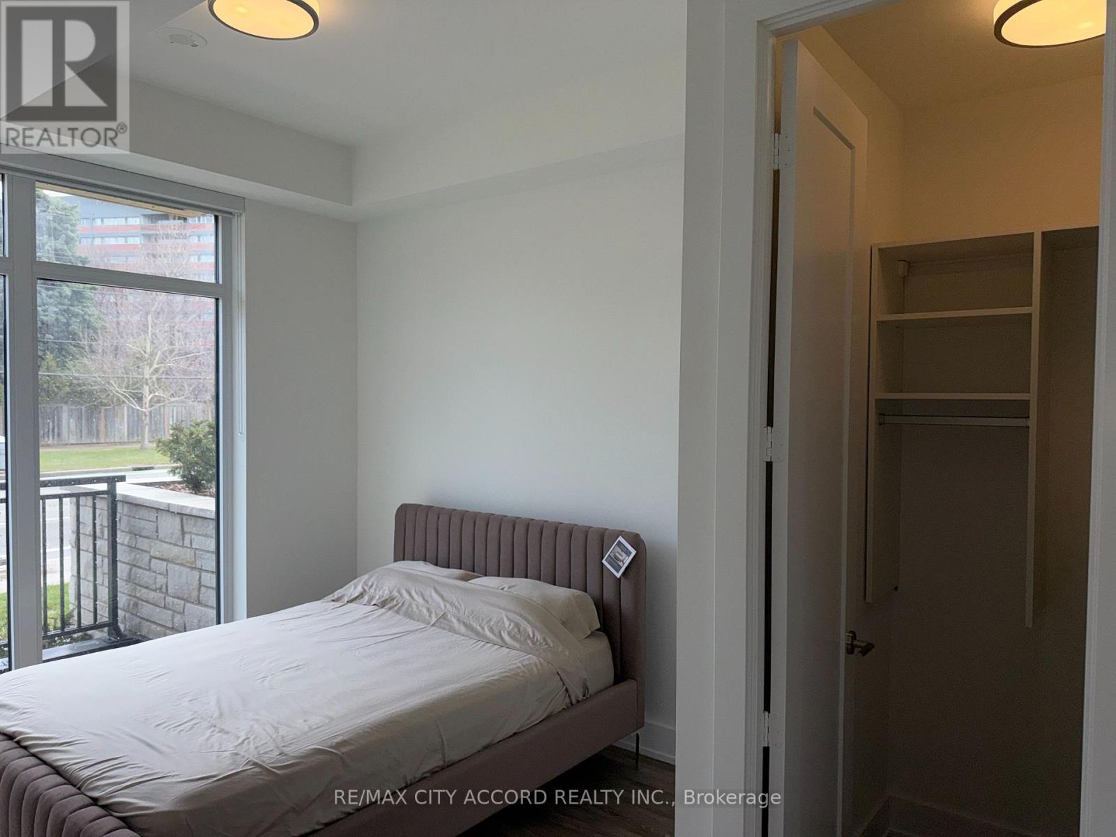 A bedroom with a bed, a window, and a door.