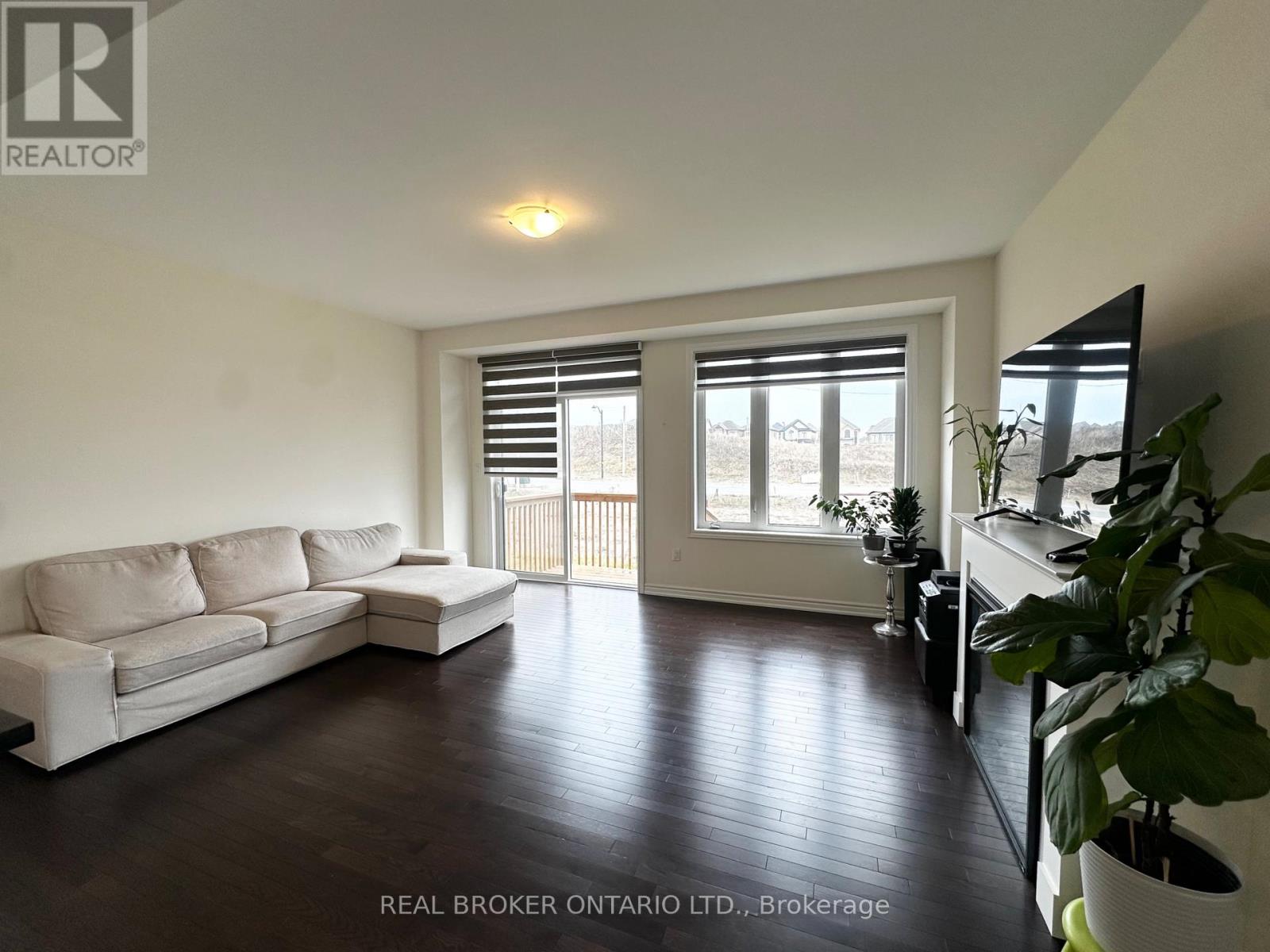 A living room with a white couch and a television.
